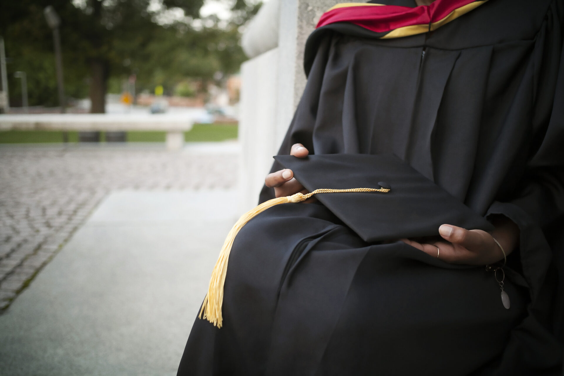 Mid-section of woman holding mortarboard